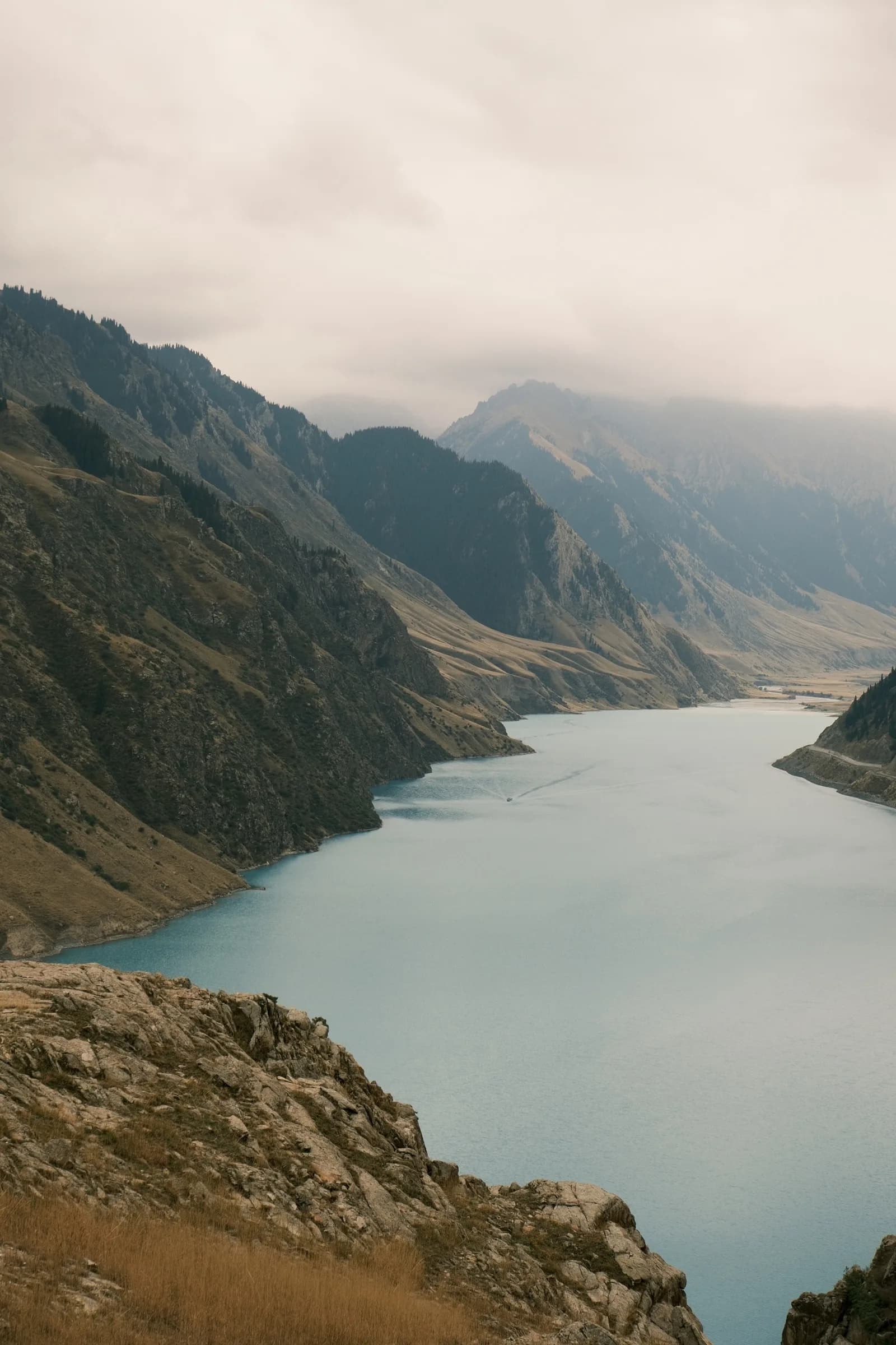 Turquoise lake winding between steep rocky ridges