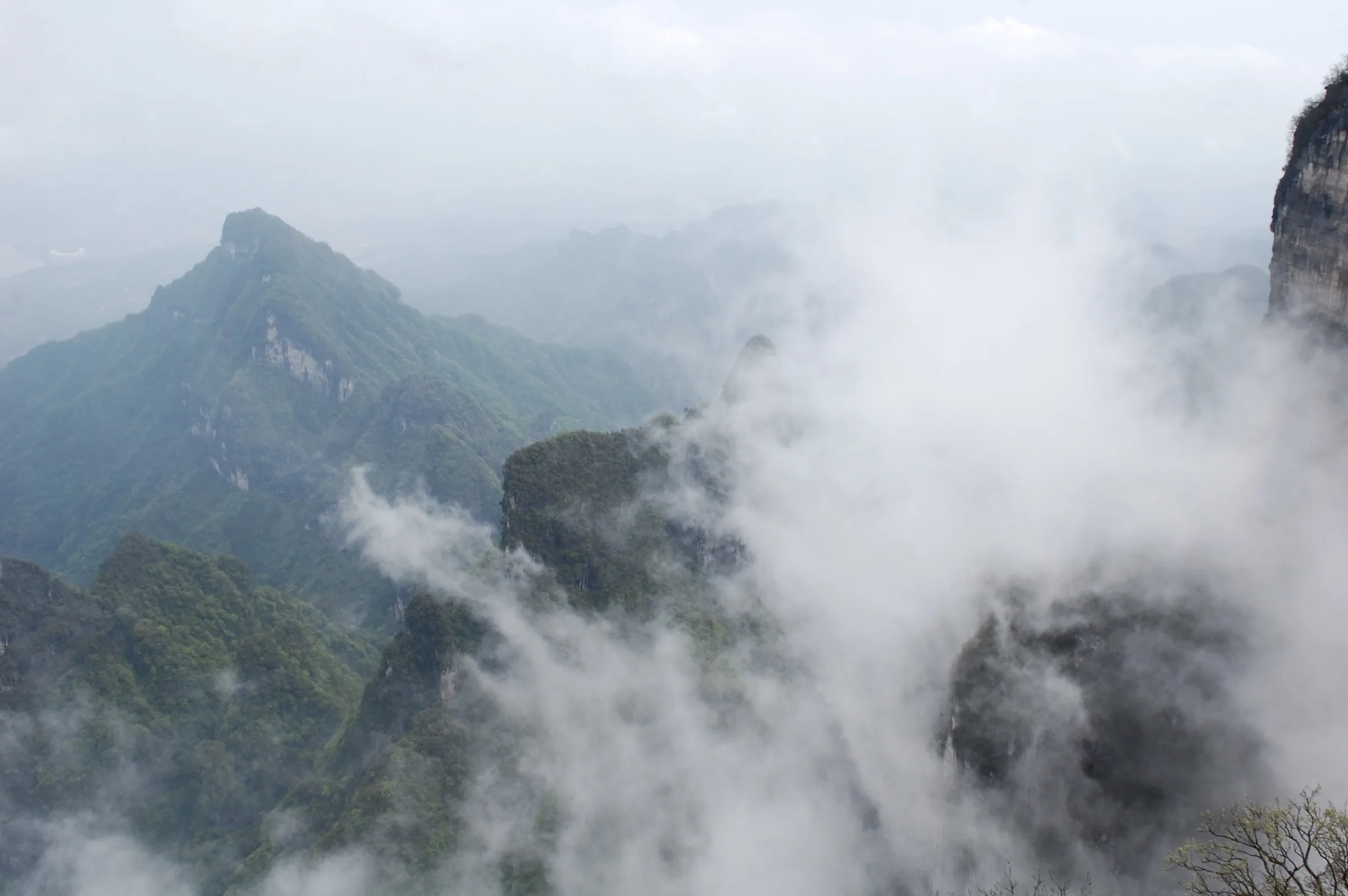 Mist pouring between jagged green peaks