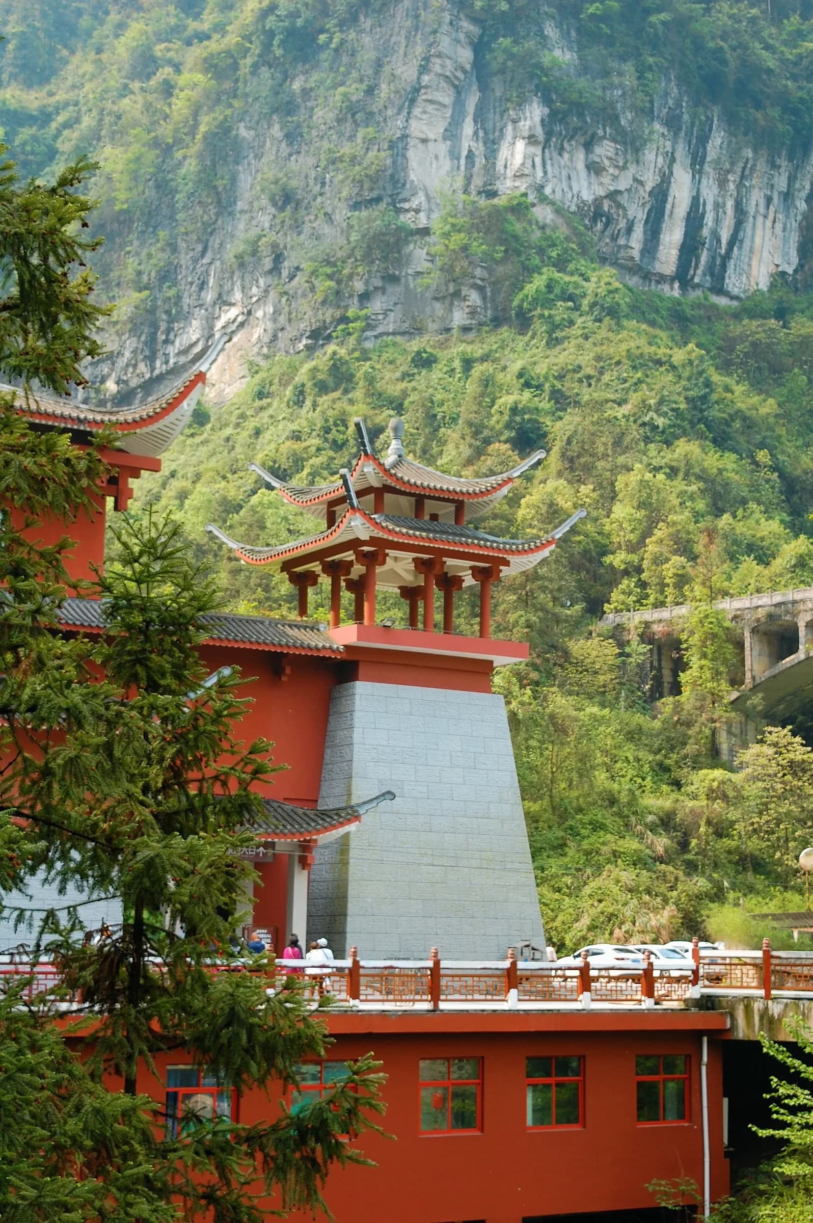An orange timber gatehouse set against a sheer cliff
